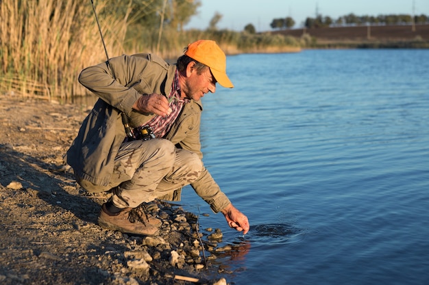 Premium Photo | Fisherman standing on the riverside and trying to catch a fish. sport, recreation, lifestyle.